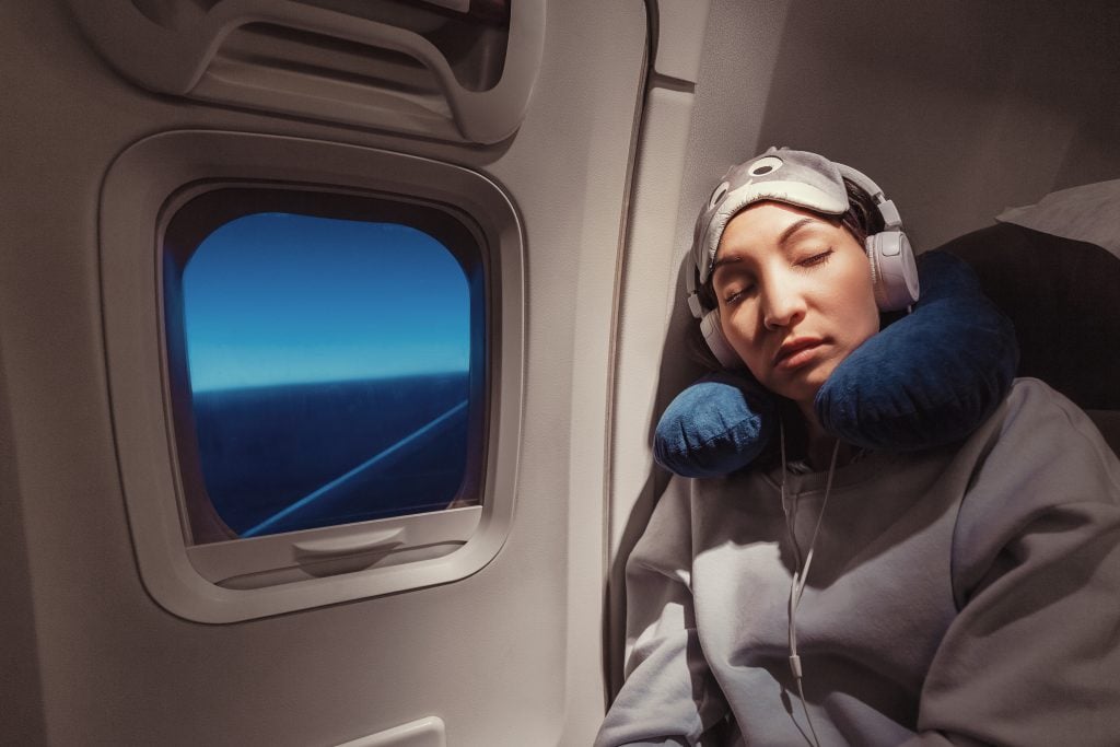 Mulher em voo dormindo no assento
