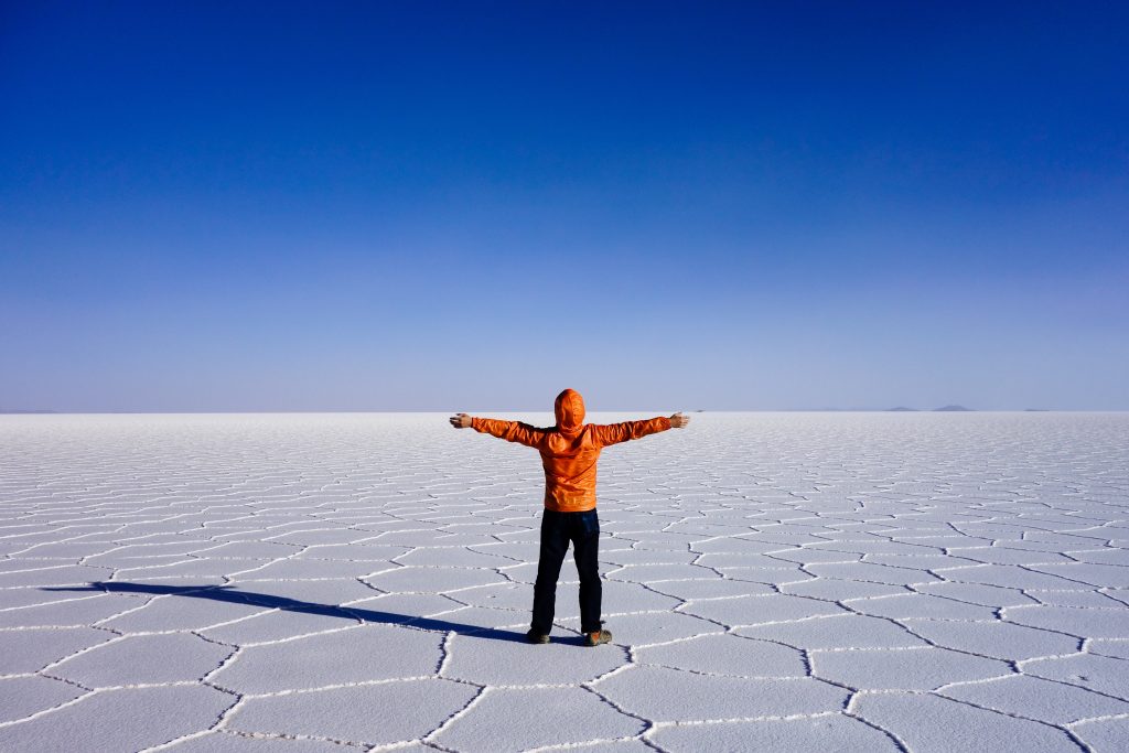 Pessoa de braços abertos no deserto de Uyuni