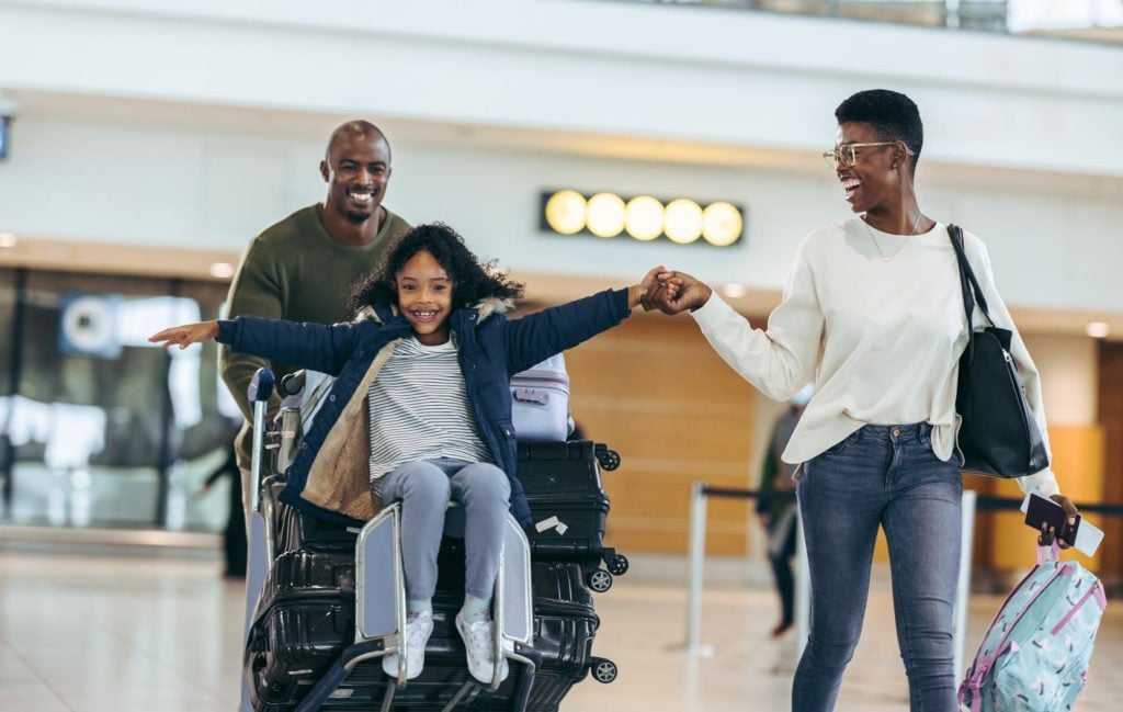 Família empurrando malas em aeroporto